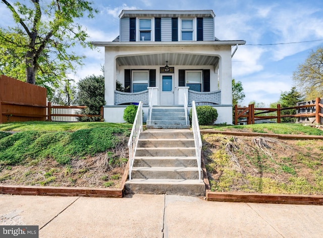 bungalow-style house featuring a porch, fence, and stucco siding