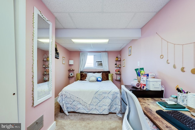 bedroom with carpet floors, visible vents, and a drop ceiling