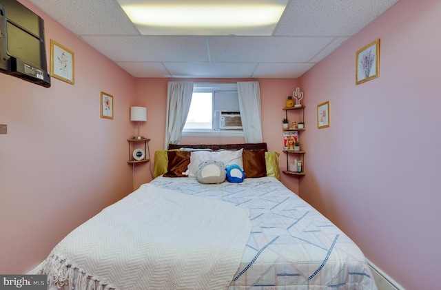 bedroom with a paneled ceiling and cooling unit