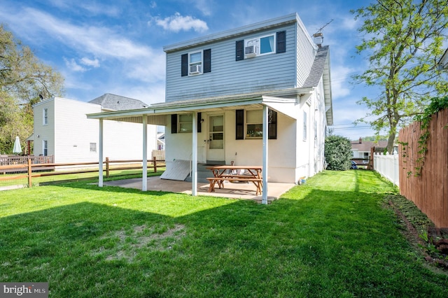 back of property with a lawn, a chimney, a fenced backyard, and a patio area