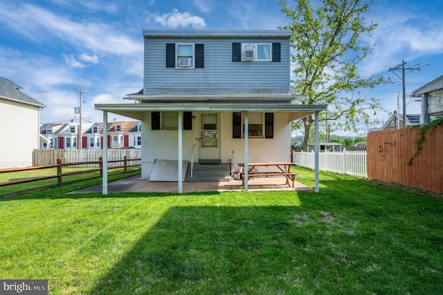 back of house featuring a yard, a patio, and a fenced backyard