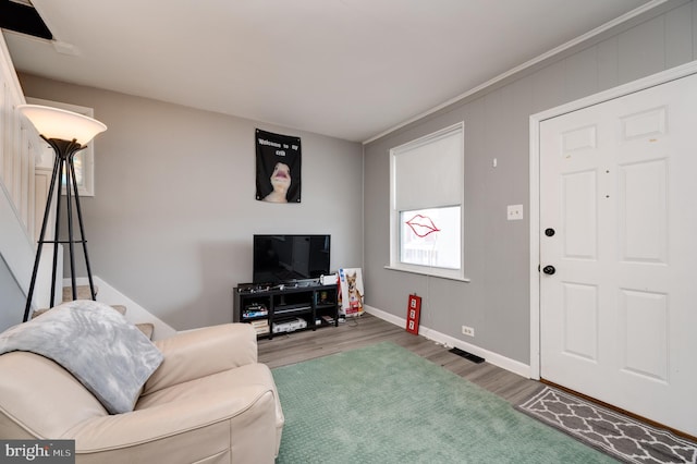 living room featuring baseboards, wood finished floors, and visible vents