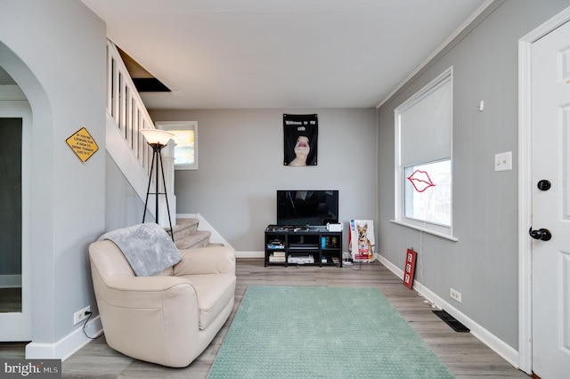 living area with stairway, arched walkways, and a wealth of natural light