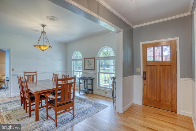 foyer featuring ornamental molding, light wood finished floors, and wainscoting