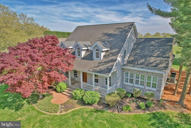 rear view of property with a porch and roof with shingles