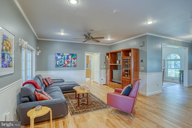 living area with a ceiling fan, crown molding, wainscoting, wood finished floors, and recessed lighting