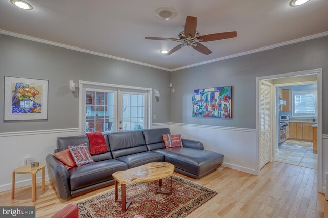 living room with ceiling fan, ornamental molding, a wealth of natural light, and light wood-style floors