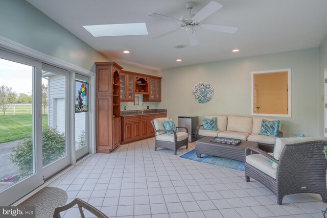 living area featuring light tile patterned floors, indoor wet bar, a ceiling fan, and recessed lighting