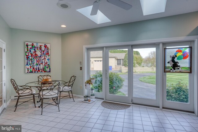 interior space with a ceiling fan, a skylight, light tile patterned floors, baseboards, and recessed lighting