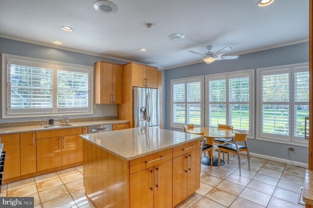 kitchen with a sink, appliances with stainless steel finishes, and ornamental molding