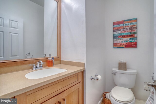 bathroom featuring vanity, baseboards, and toilet