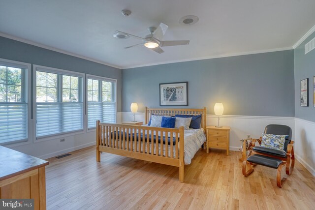 bedroom with visible vents, baseboards, crown molding, and light wood-type flooring