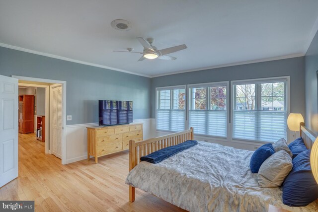 bedroom featuring crown molding, multiple windows, and light wood-style flooring