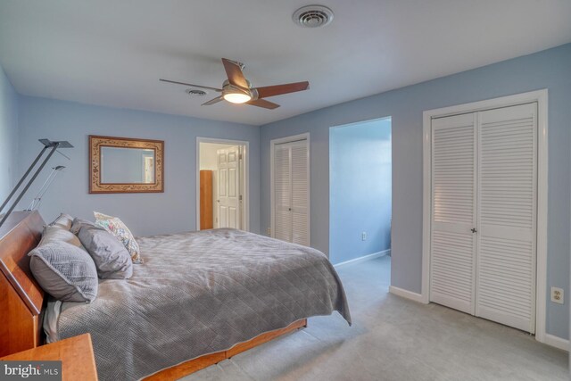 bedroom featuring baseboards, two closets, carpet floors, and visible vents