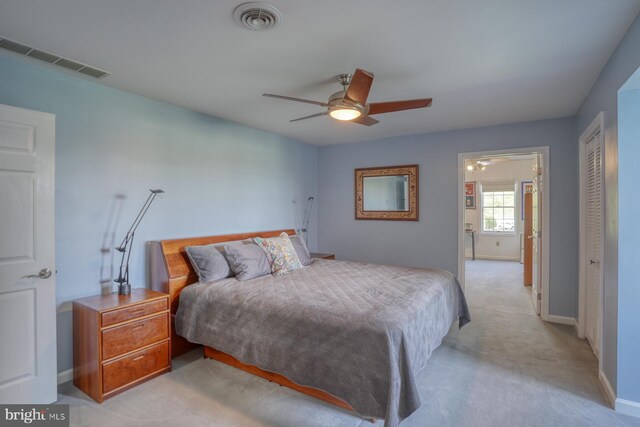 bedroom featuring baseboards, a closet, light colored carpet, and visible vents