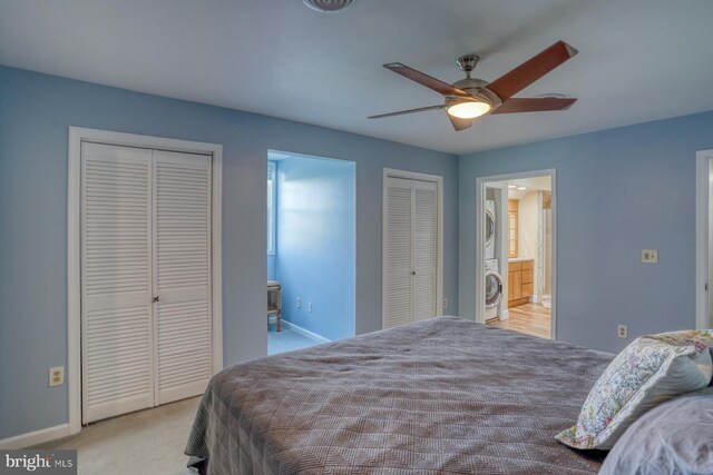 carpeted bedroom with baseboards, multiple closets, stacked washing maching and dryer, and ensuite bathroom