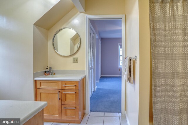 bathroom with baseboards, tile patterned floors, and vanity