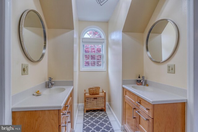 bathroom with tile patterned flooring, a sink, baseboards, and two vanities
