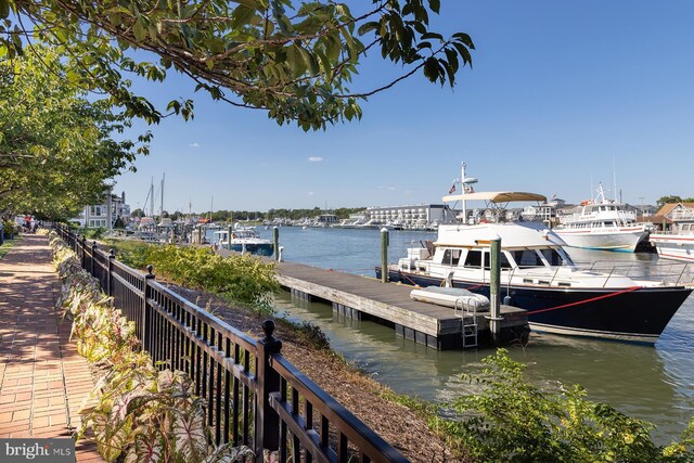 dock area featuring fence and a water view
