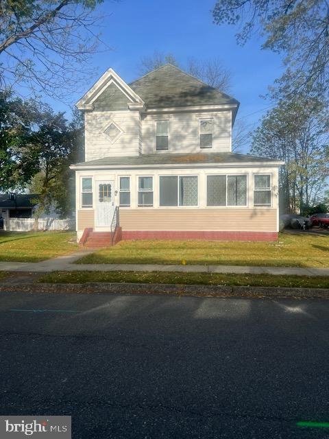 traditional home with a front yard, fence, and entry steps