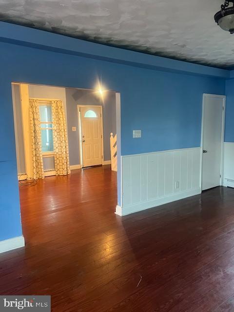 interior space with wood-type flooring and baseboards