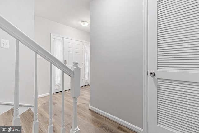 interior space with baseboards, light wood finished floors, and stairs