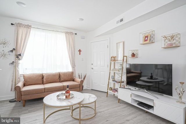 living room featuring baseboards, wood finished floors, and visible vents