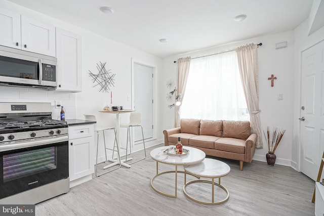 living room with baseboards and light wood-style flooring
