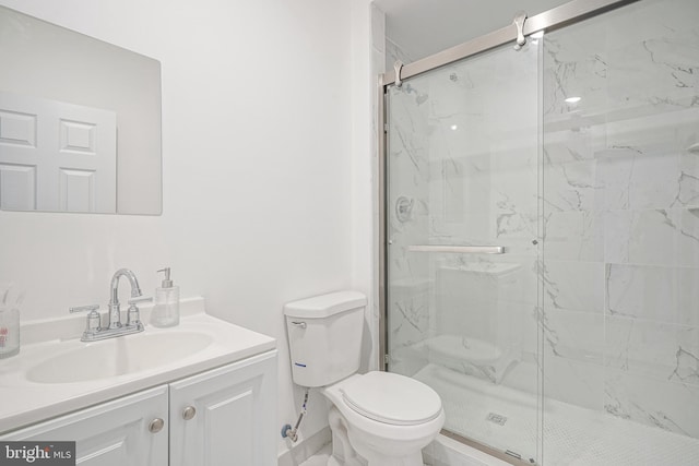 full bathroom featuring a marble finish shower, vanity, and toilet