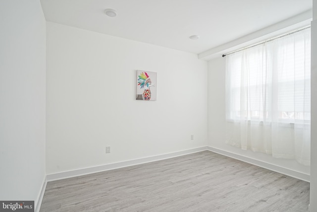 spare room featuring baseboards and wood finished floors