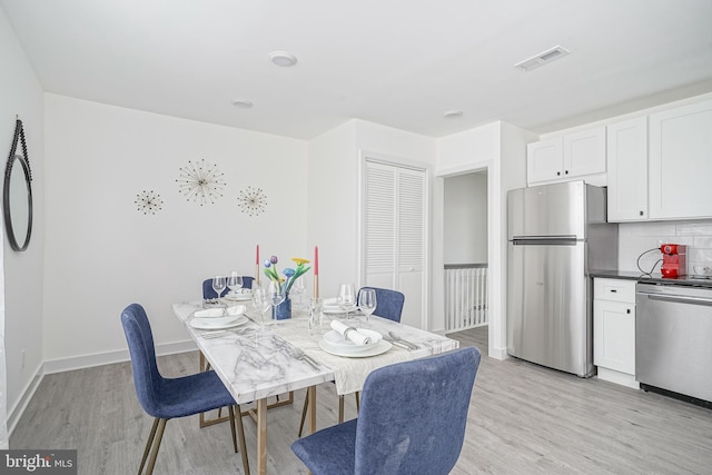 dining area featuring visible vents, baseboards, and light wood-type flooring
