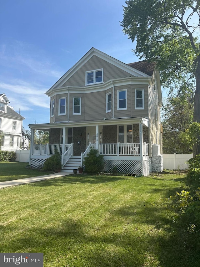 view of front of house with a porch, a front lawn, and fence