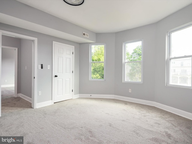 unfurnished bedroom featuring baseboards, carpet flooring, and visible vents