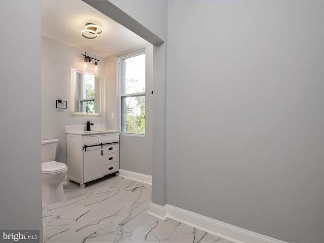 bathroom featuring baseboards, vanity, toilet, and marble finish floor