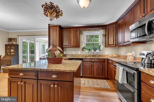 133 Teal Dr, Pasadena, MD 21122 - kitchen with stainless steel appliances, light wood-type flooring, ornamental molding, a center island, and light stone countertops