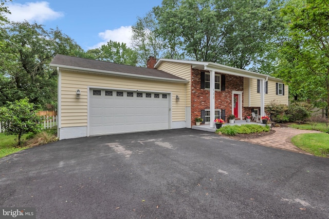 133 Teal Dr, Pasadena, MD 21122 - split foyer home with driveway, a chimney, a garage, brick siding, and fence