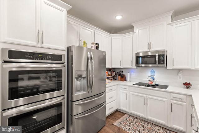 10424 Ratcliffe Trl, Manassas, VA 20110 - kitchen featuring wood finished floors, recessed lighting, white cabinetry, light countertops, and appliances with stainless steel finishes