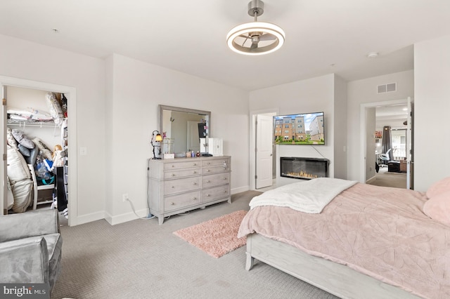 10424 Ratcliffe Trl, Manassas, VA 20110 - carpeted bedroom with a closet, visible vents, a spacious closet, baseboards, and a glass covered fireplace