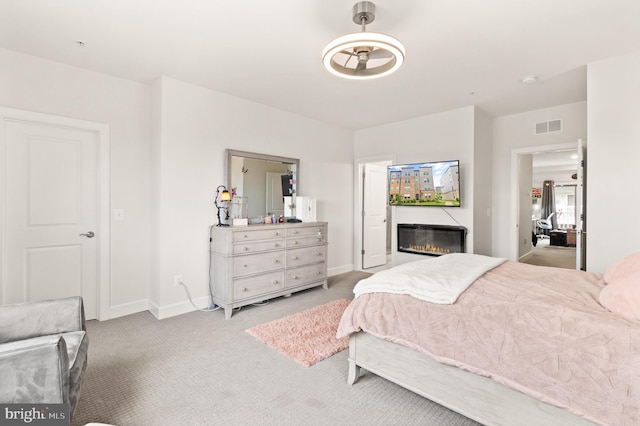 10424 Ratcliffe Trl, Manassas, VA 20110 - carpeted bedroom with baseboards, a glass covered fireplace, and visible vents