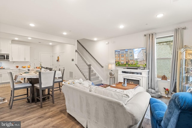 10424 Ratcliffe Trl, Manassas, VA 20110 - living room featuring a premium fireplace, recessed lighting, light wood finished floors, visible vents, and stairway