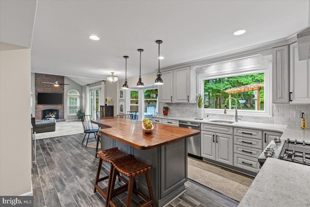1301 Kelly Ct, Herndon, VA 20170 - kitchen with wood counters, stainless steel dishwasher, a sink, open floor plan, and a kitchen bar