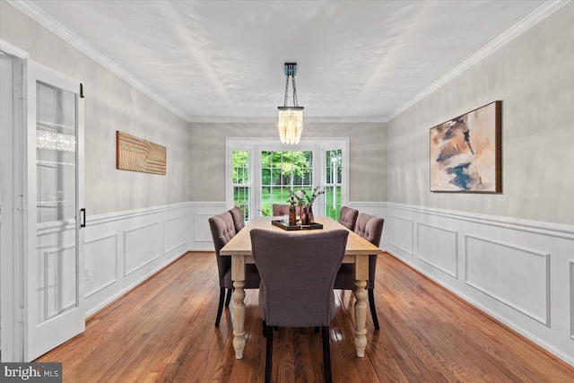1301 Kelly Ct, Herndon, VA 20170 - dining space featuring wood finished floors, a decorative wall, wainscoting, and crown molding