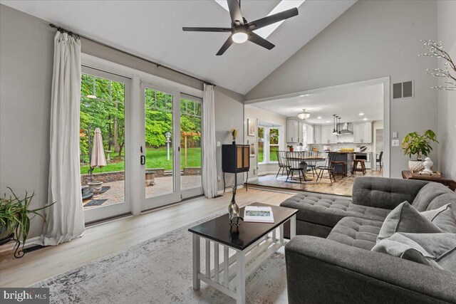 1301 Kelly Ct, Herndon, VA 20170 - living area with high vaulted ceiling, light wood-type flooring, ceiling fan, and baseboards