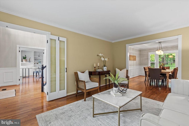 1301 Kelly Ct, Herndon, VA 20170 - living room with ornamental molding, wood finished floors, french doors, a wainscoted wall, and a decorative wall