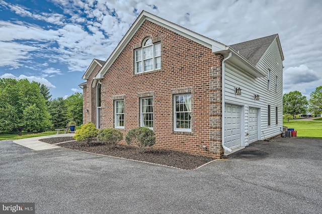 12439 Barnard Way SW, West Friendship, MD 21794 - view of home's exterior featuring a garage, brick siding, and aphalt driveway