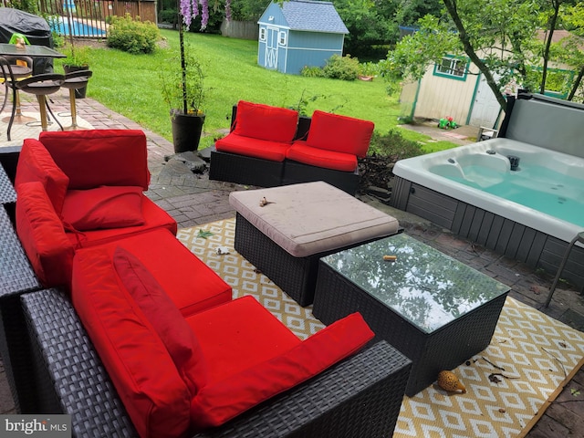 view of patio featuring an outdoor living space, a storage unit, an outbuilding, and a hot tub