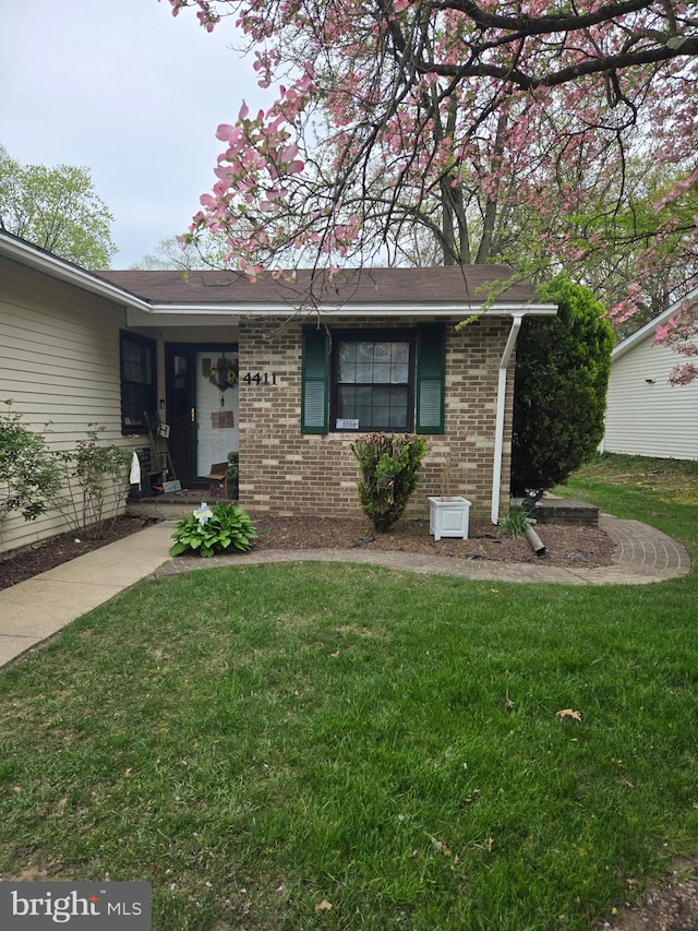 ranch-style house with brick siding and a front yard