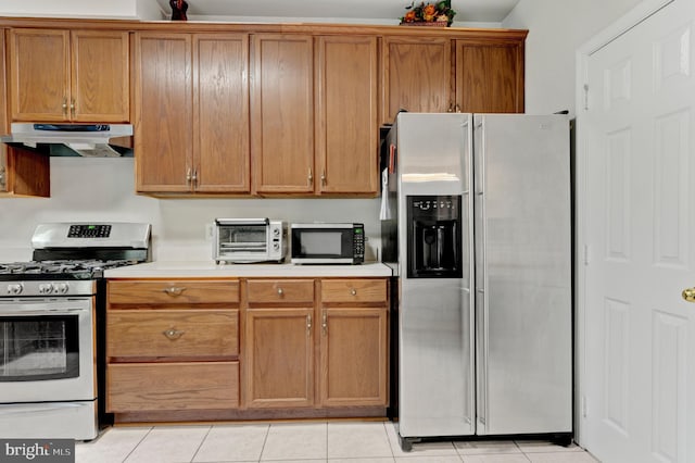 kitchen with a toaster, appliances with stainless steel finishes, under cabinet range hood, and light countertops