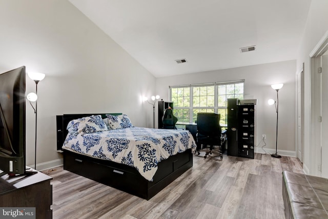 bedroom featuring baseboards, high vaulted ceiling, wood finished floors, and visible vents