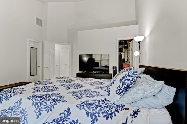 bedroom with a high ceiling and visible vents